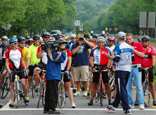 Photo of Coach Jim Calhoun speaking to a group of bike riders