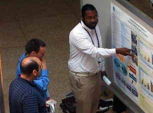 Photo of Ailton Coleman discussing his research with Brandon Albright and Kareem Mohni