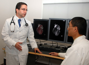 Drs. Erick Avelar (left) and Clifford Yang read cardiac CT images in the Department of Diagnostic Imaging and Therapeutics. Yang is one of Avelars co-investigators in the Health Centers participation in the PROMISE study.