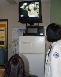 Coworkers catch a glimpse of the televised wedding in the seventh-floor lounge