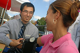 Hee Seop Shin, a second-year medical student, takes a blood pressure reading at C-Town Supermarket in Hartford.