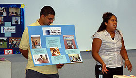 Neli Rivera, right, a Youth Health Service Corps student from Harding High School in Bridgeport, explains her service learning project to conference participants from around the country, as staff member Rick Cruz looks on.