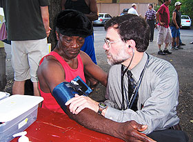 Dr. Bruce Gould examines a seasonal worker at a tobacco farm in Enfield, providing care as a physician with the Mobile Free Migrant Farmworker Clinic.