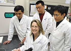 Liisa Kuhn (seated) with, from left, postdoctoral fellows Guomin Ou, Bo Wen, and Yongxing Liu in a biomaterials lab at the UConn Health Center.