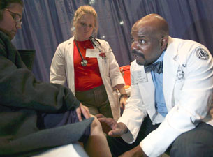 Photo of Devon Root checking the blood pressure of a pregnant woman