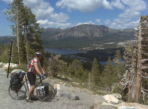 A man on a bicycle overlooking a scenic mountain vista