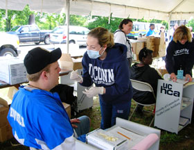 Fourth-year dental students Tara Valiquette, center, and Ivelina Jurkowski, right, provide dental care and screening to some of the participants in the 2006 Special Olympics.