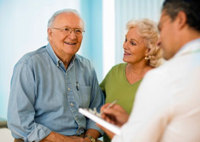 Photo of older couple speaking to physician