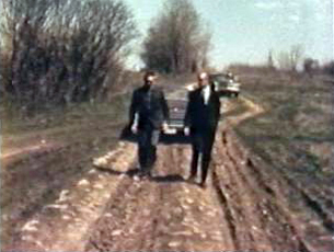 Two men walking down a dirt road toward the construction site