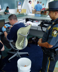 Photo of a Health Center police officer and a volunteer handling a prescription medication vial