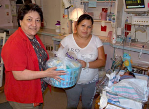 Photo of a Bank of America employee presenting a gift basket to a NICU mother