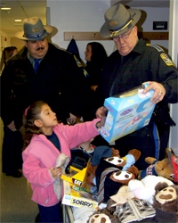 A child shows State Police Sgt. Nick Poppitti and Lt. Paul Vance one of the toys state troopers brought to the NICU