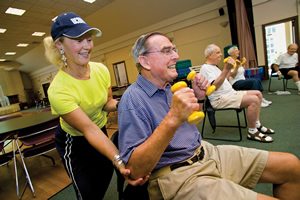 Mary Carroll Root helps participants during a Powerful Aging exercise class at the Avon Senior Center