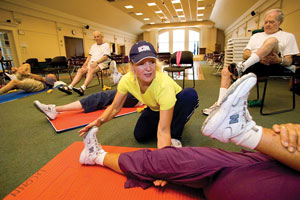 Mary Carroll Root helps participants during a Powerful Aging exercise class at the Avon Senior Center