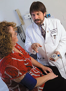 Dr. William White, right, confers with a patient. White is a co-investigator on an NIH-funded study that will look at the relationship between smoking, quitting, and high blood pressure.
