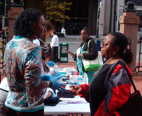 UConn medical student Abimbola Sunmonu, left, at a School of Medicine health fair at the Old State House in Hartford.